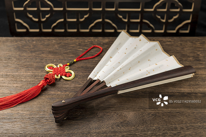 一把中国传统折扇纸扇摆放在桌面上特写图片素材