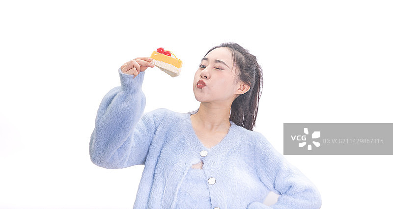 白色背景前拿着蛋糕甜点的搞怪表情女孩图片素材