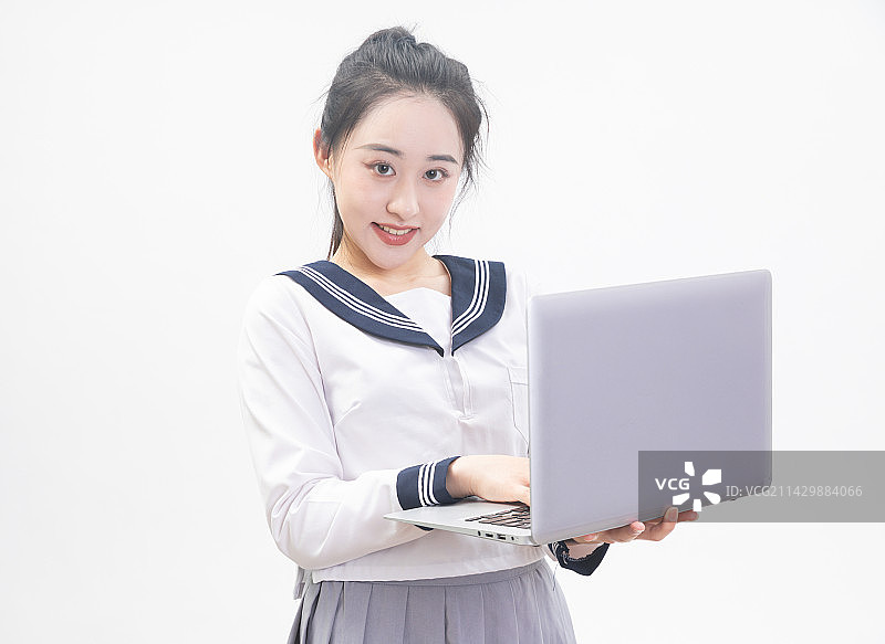白背景前拿着笔记本电脑的青年女学生半身肖像图片素材
