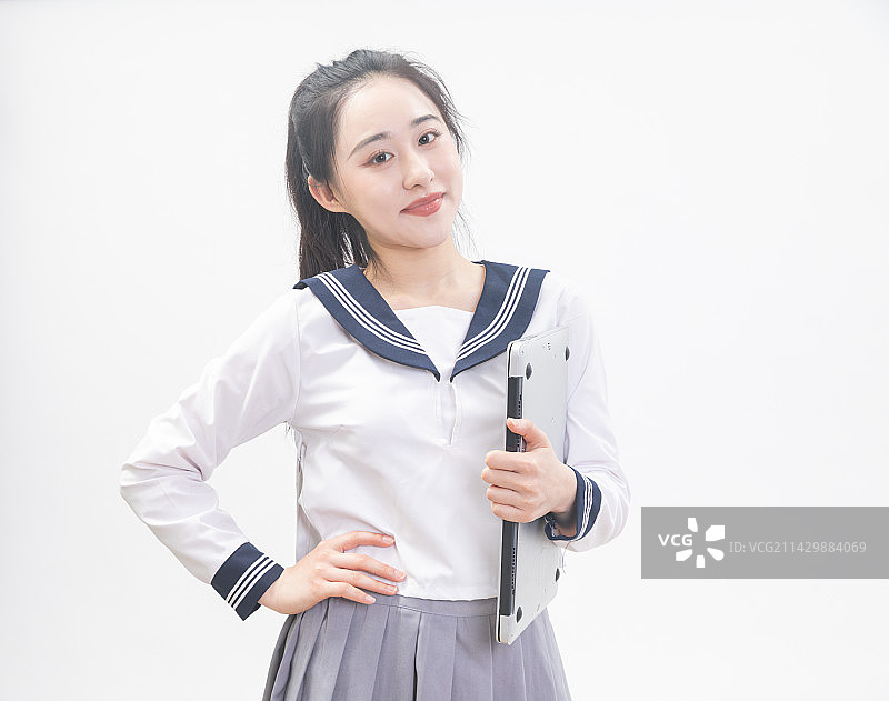 白背景前拿着笔记本电脑的青年女学生半身肖像图片素材