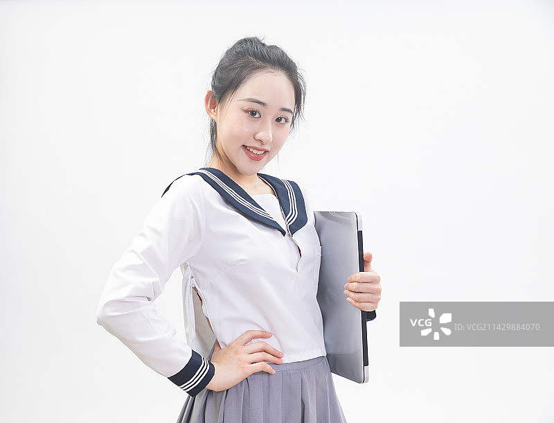 白背景前拿着笔记本电脑的青年女学生半身肖像图片素材