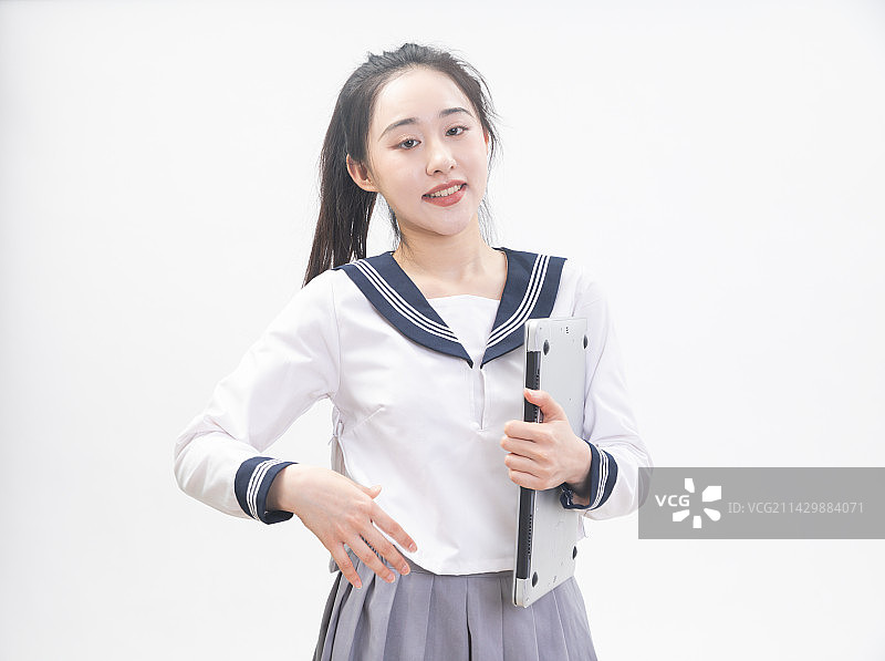 白背景前拿着笔记本电脑的青年女学生半身肖像图片素材