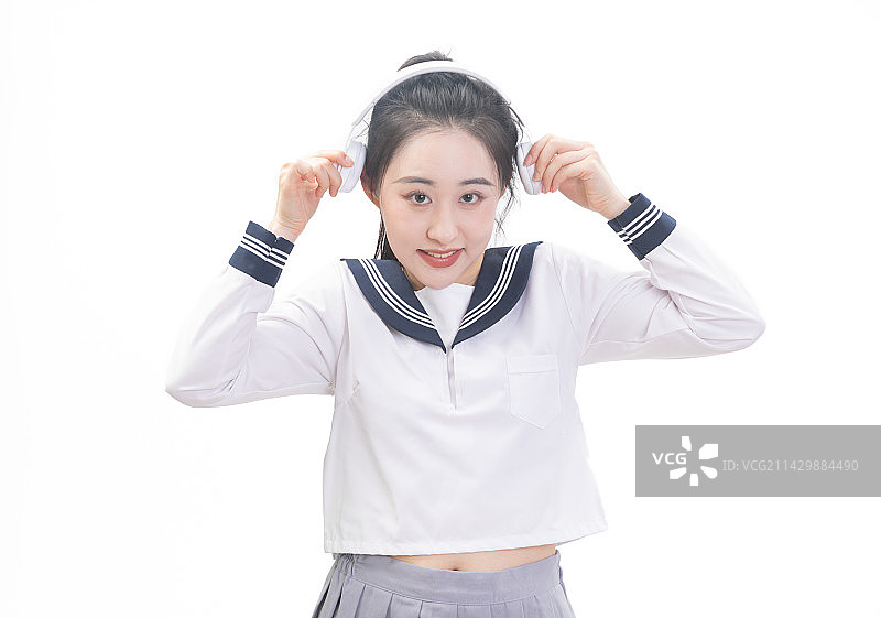 白背景前带着耳机穿学生服的青年女学生图片素材