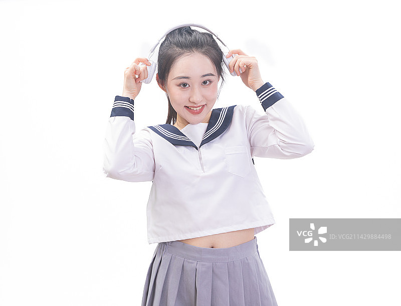 白背景前带着耳机穿学生服的青年女学生图片素材