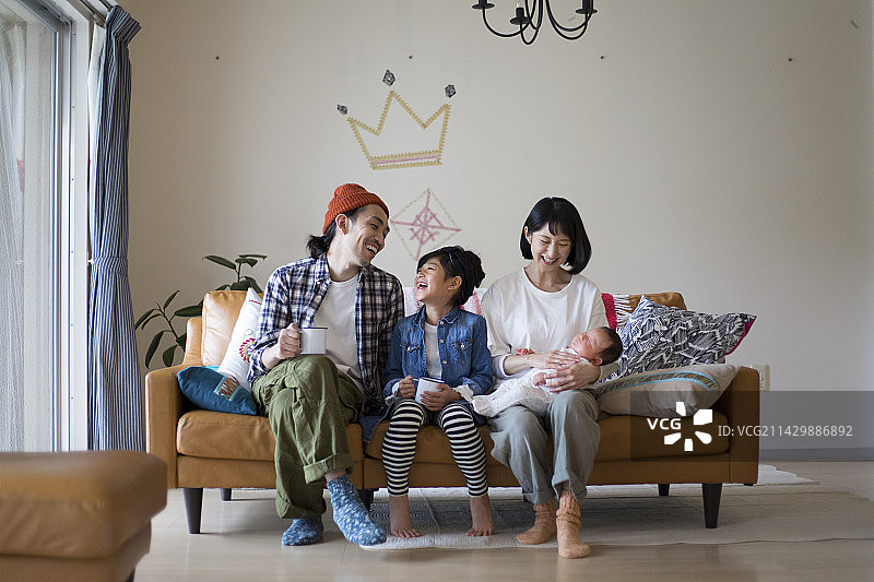 家庭在客厅的沙发上放松图片素材