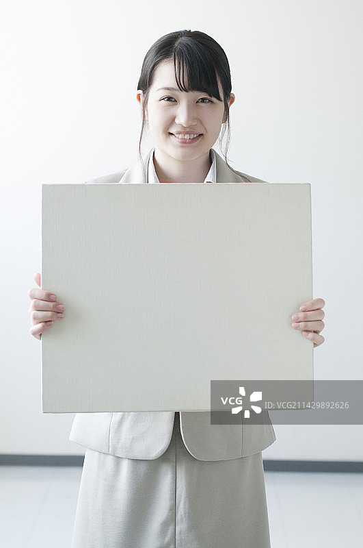 老师拿着白板微笑图片素材