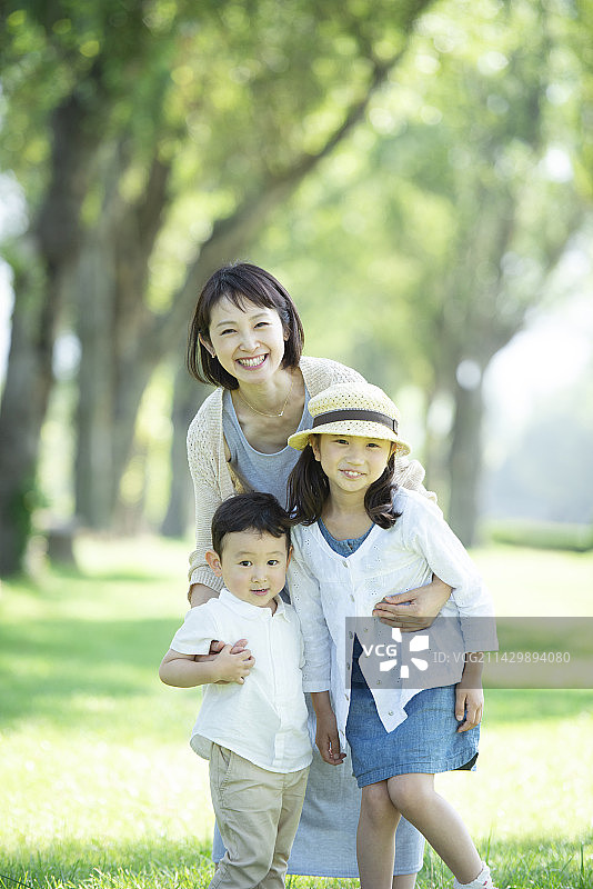 在成排的杨树中面带微笑的父母和孩子图片素材