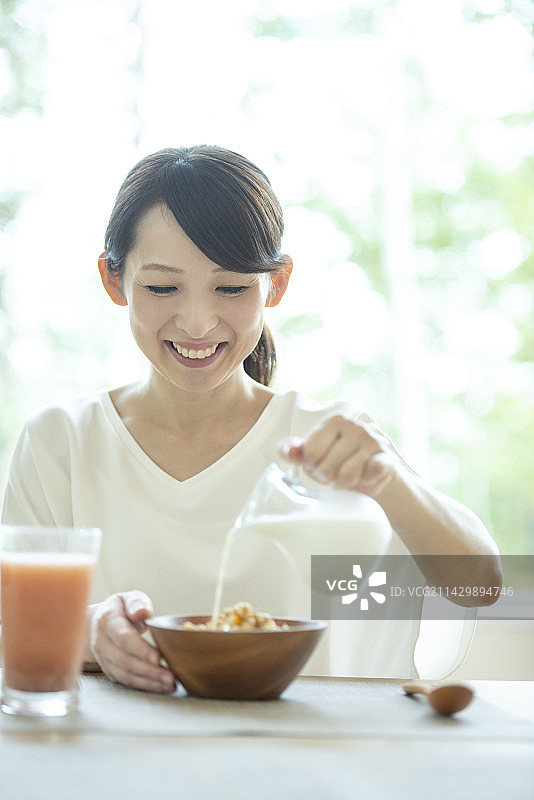 女子将牛奶倒入麦片图片素材