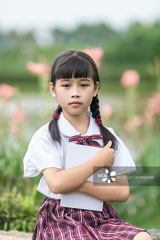 户外一个中国小学生在看书图片素材