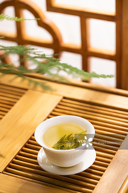 一杯清新的龙井茶放在茶盘上图片素材