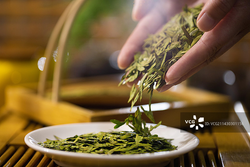 双手捧起龙井茶叶图片素材