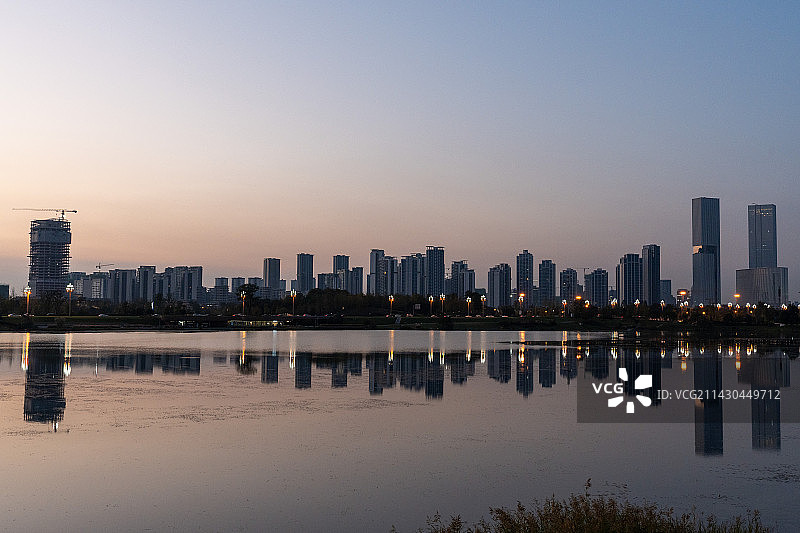 夕阳下城市建筑轮廓倒影图片素材