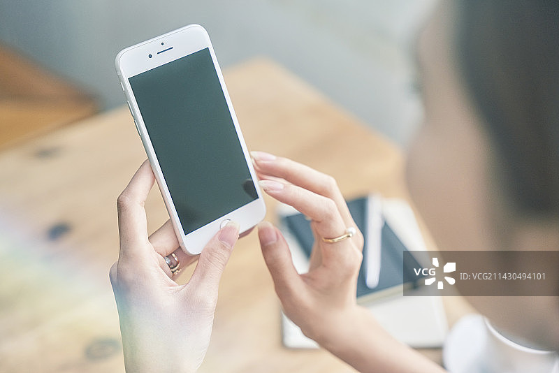 女子操作智能手机图片素材