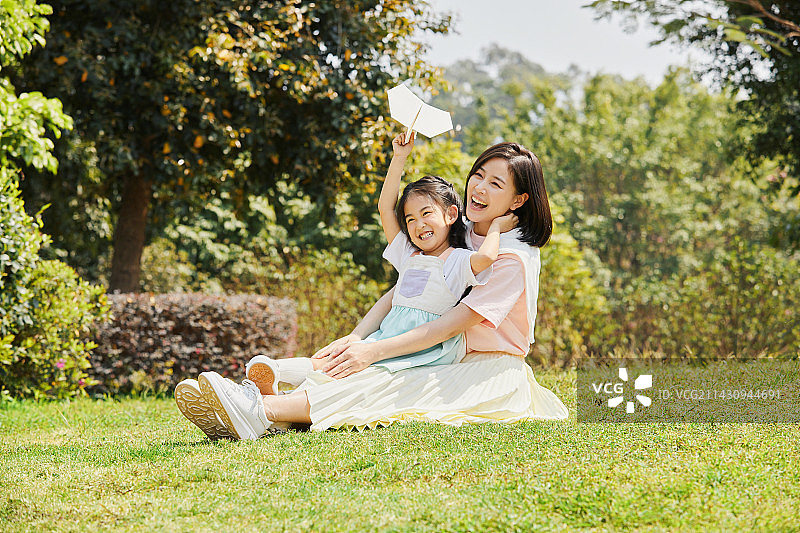坐在妈妈身上的小女孩手拿纸飞机图片素材