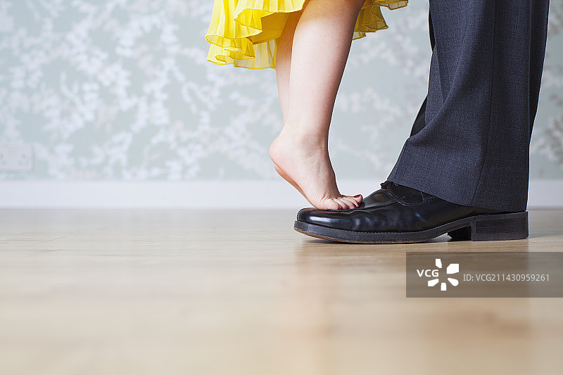 站在父亲脚上的年轻女孩图片素材