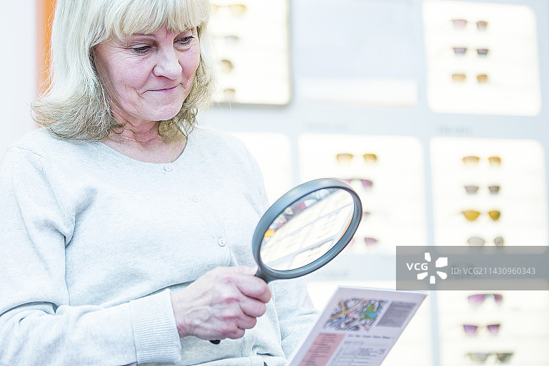 年长的女人拿着放大镜图片素材