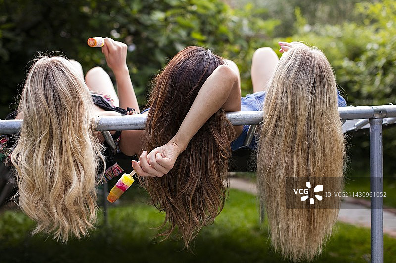 躺在蹦床上的三个年轻女人图片素材