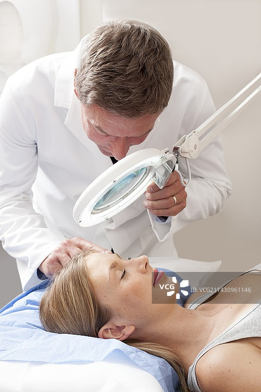 医生检查年轻女人的脸图片素材