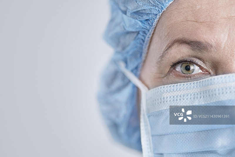 戴着外科口罩和帽子的女外科医生图片素材