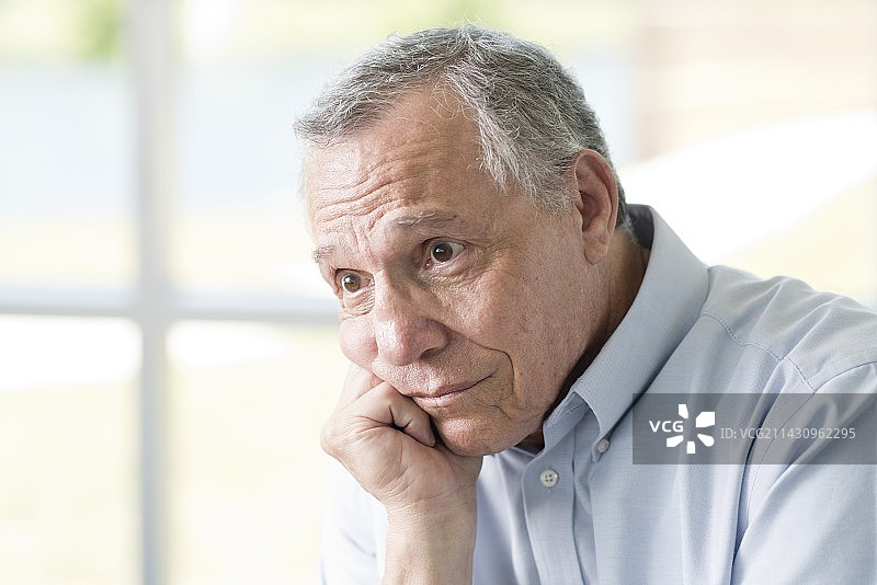 手托下巴望向远方的年长男人图片素材