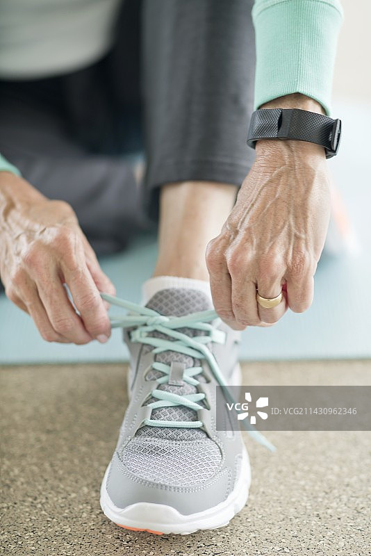 年长的女人系紧运动鞋图片素材