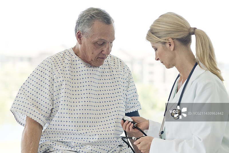女医生为年长男人量血压图片素材