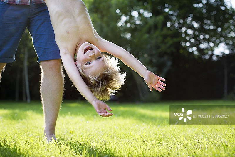 父亲倒抱儿子在户外图片素材