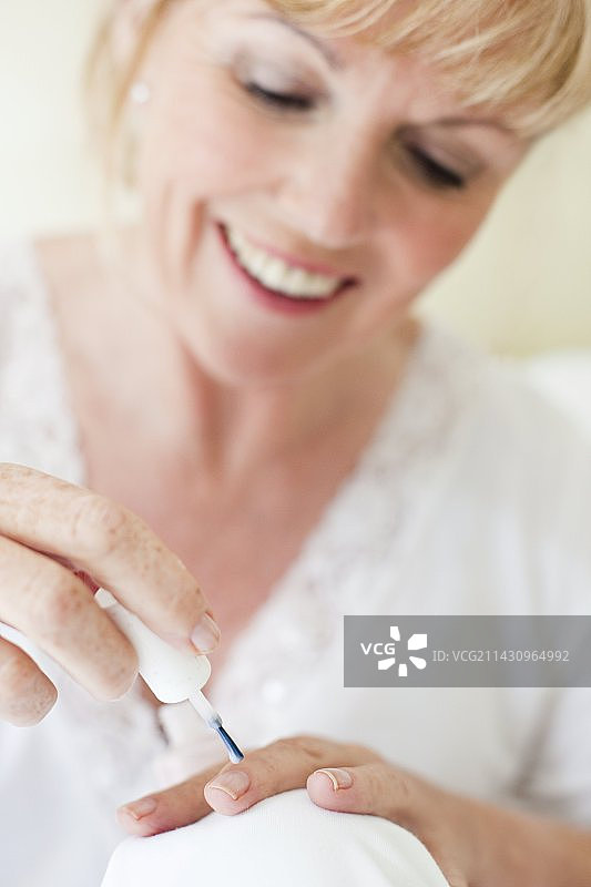 老年妇女在涂指甲油图片素材