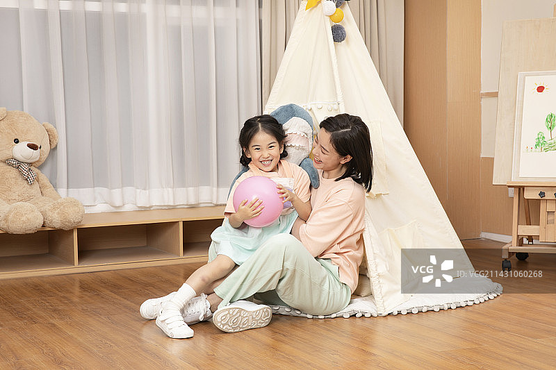 坐在地板上与母亲互动的小女孩图片素材