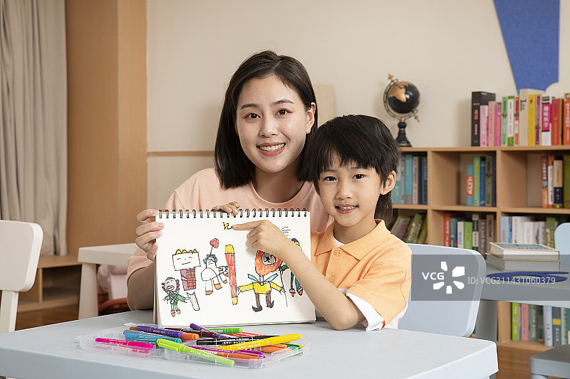 辅导男孩画画的女老师图片素材