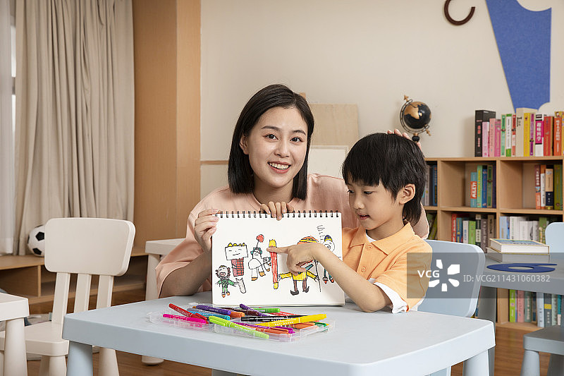 辅导男孩画画的女老师图片素材