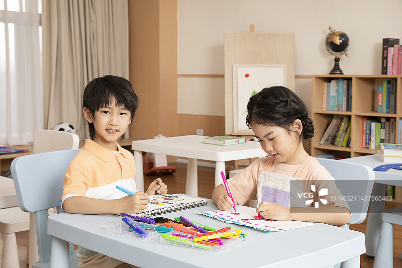 坐在一起画画学习的男孩女孩图片素材