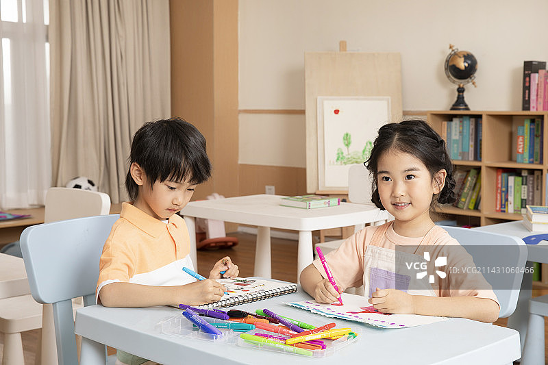 坐在一起画画学习的男孩女孩图片素材