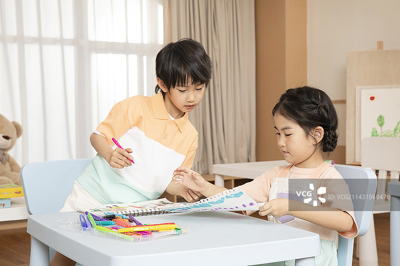 坐在一起画画学习的男孩女孩图片素材