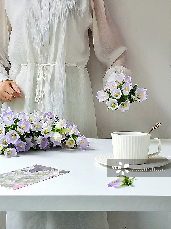 室内桌面拿花的女人局部图片素材