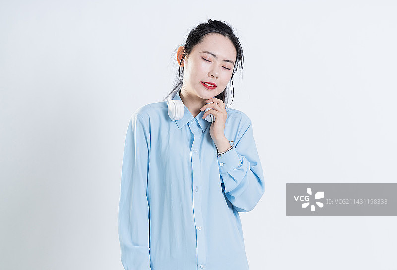 穿着蓝色衬衣戴着白色耳机的中国女孩图片素材
