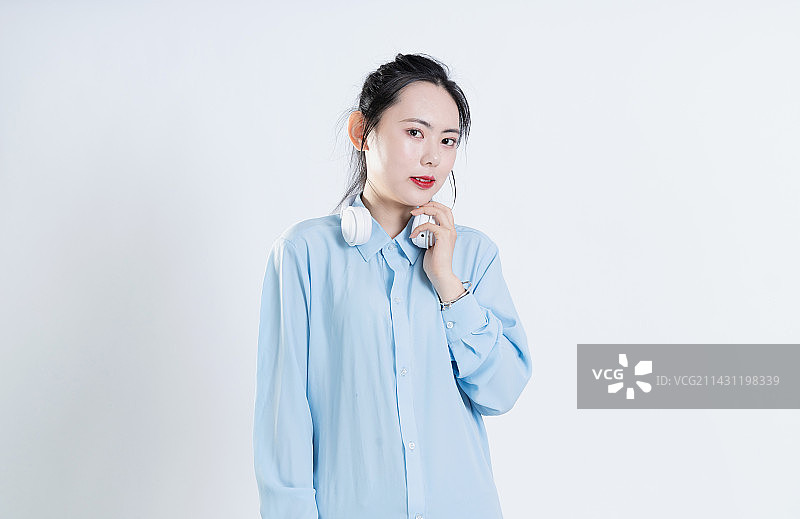 穿着蓝色衬衣戴着白色耳机的中国女孩图片素材