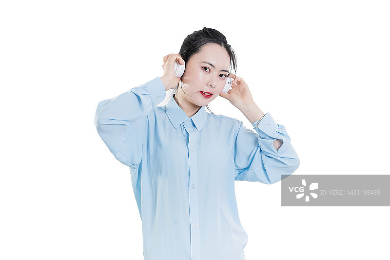穿着蓝色衬衣使用耳机的中国女孩图片素材