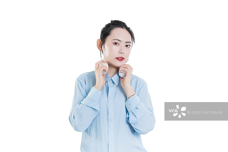穿着蓝色衬衣使用耳机的中国女孩图片素材