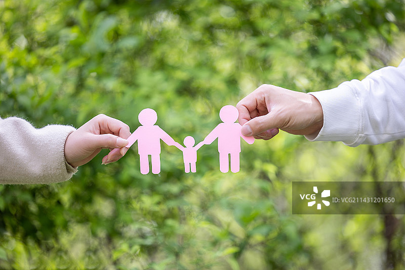 父母在春天绿色背景下拿着一家人牵手剪纸模型图片素材