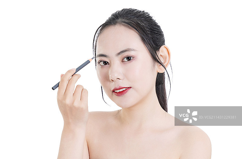 使用眉笔化妆的美容女性面部特写图片素材