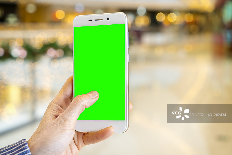 模糊的背景和女性手持触摸智能手机图片素材