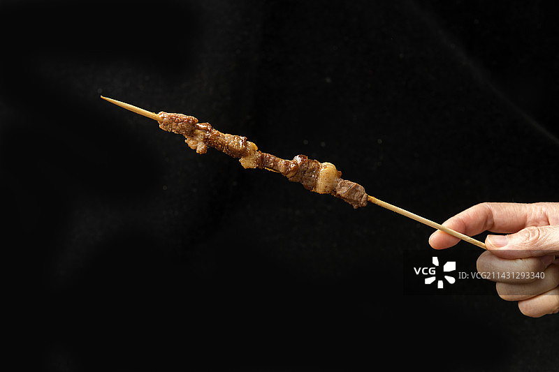 一盘烤羊肉串摆放在木桌面上特写图片素材