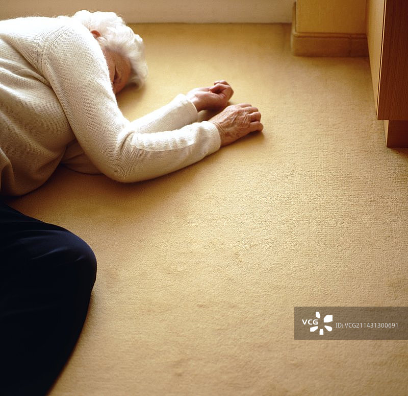 老年妇女躺在地板上图片素材