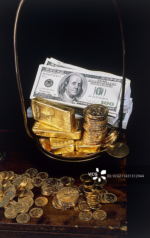 天平上的钞票、硬币和金条图片素材