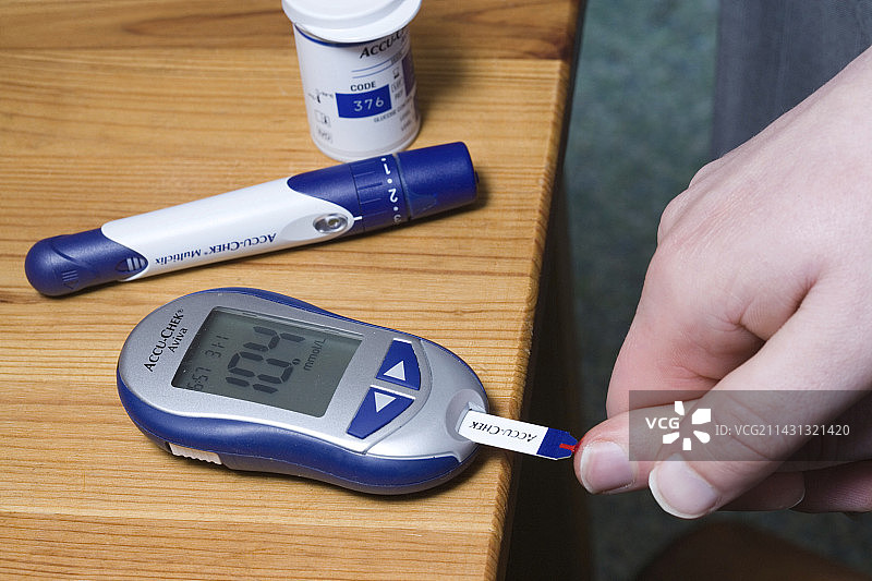 男人使用血糖仪监测糖尿病。图片素材