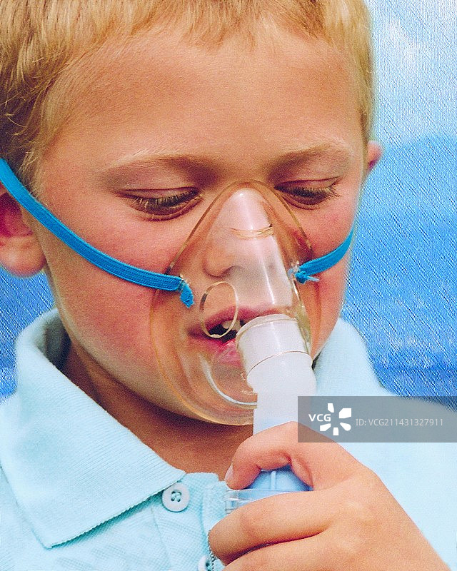 男孩使用吸入器治疗哮喘图片素材