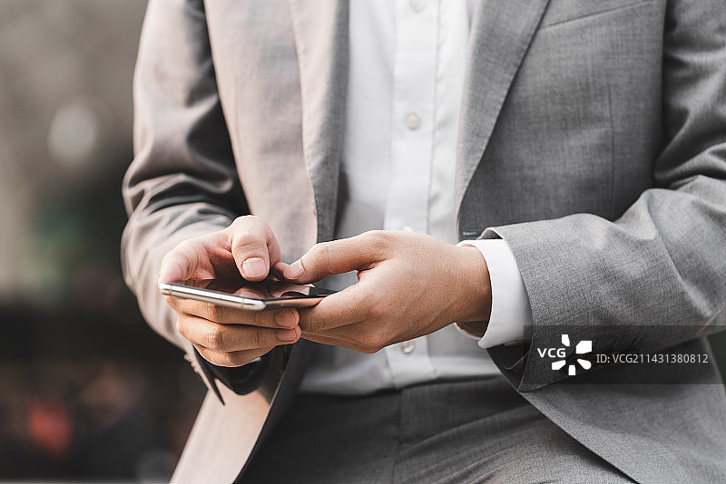 商务人士在室外使用手机的手部特写图片素材