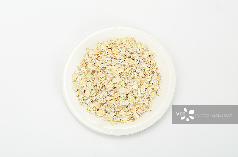 白色盘子里的燕麦片摆放在白色背景上图片素材