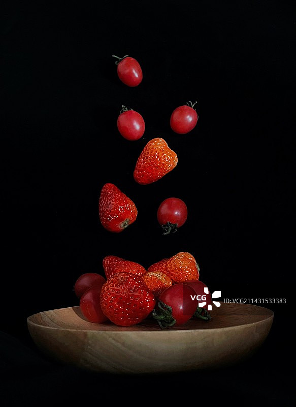 掉落盘子里的草莓和小番茄图片素材